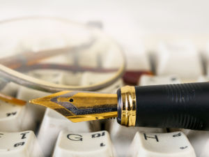 Fountain pen shot with shallow depth of field on white dirty keyboard