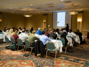 Hotel conference room full of people participating in the business training.